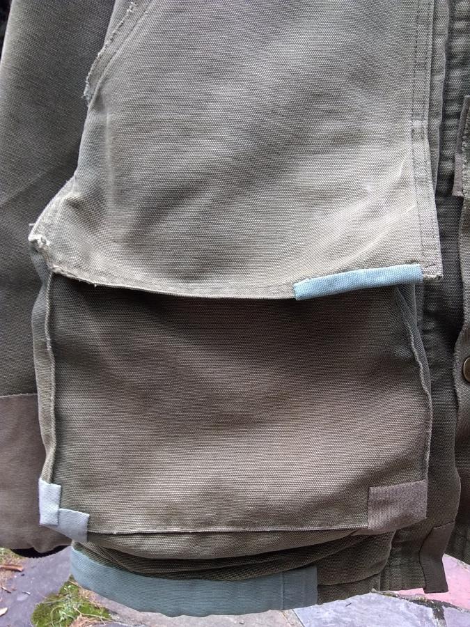 patches on the pocket and hem of a Carhartt jacket