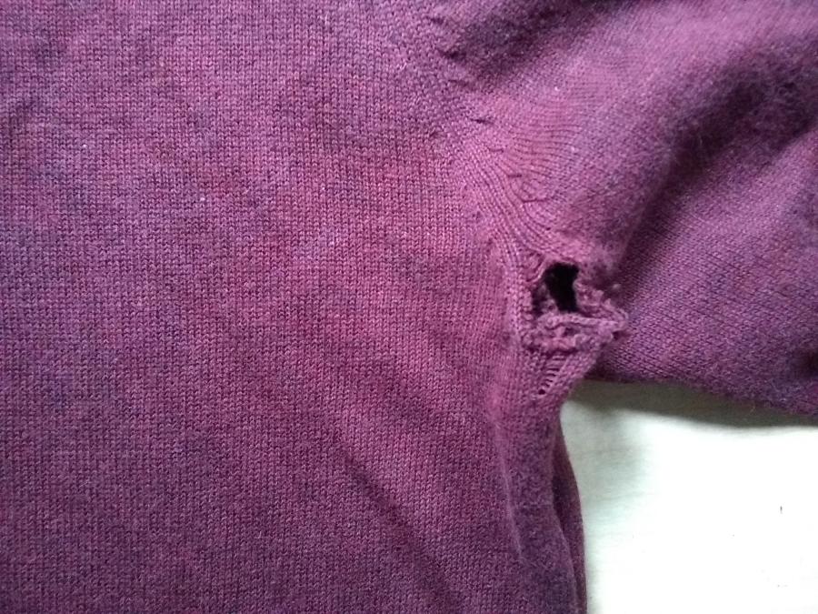 closeup of medium hole in armpit of maroon sweater