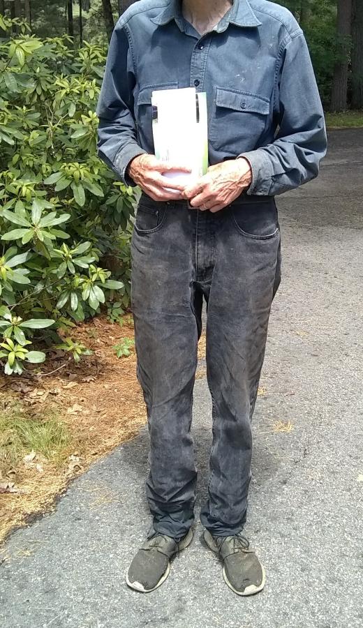 man wearing black jeans with crotch patch and leg extensions and carrying mail