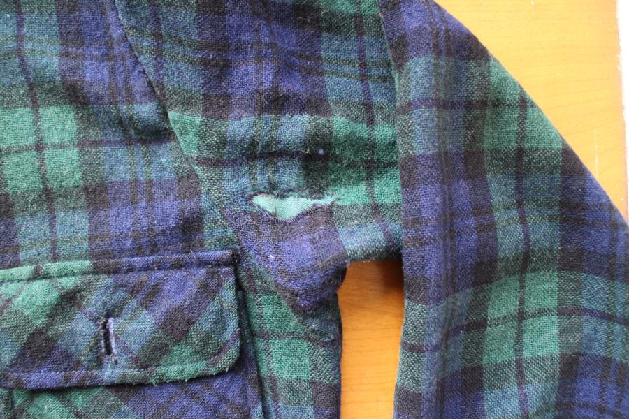 closeup of armpit of black watch shirt mended with interior patch