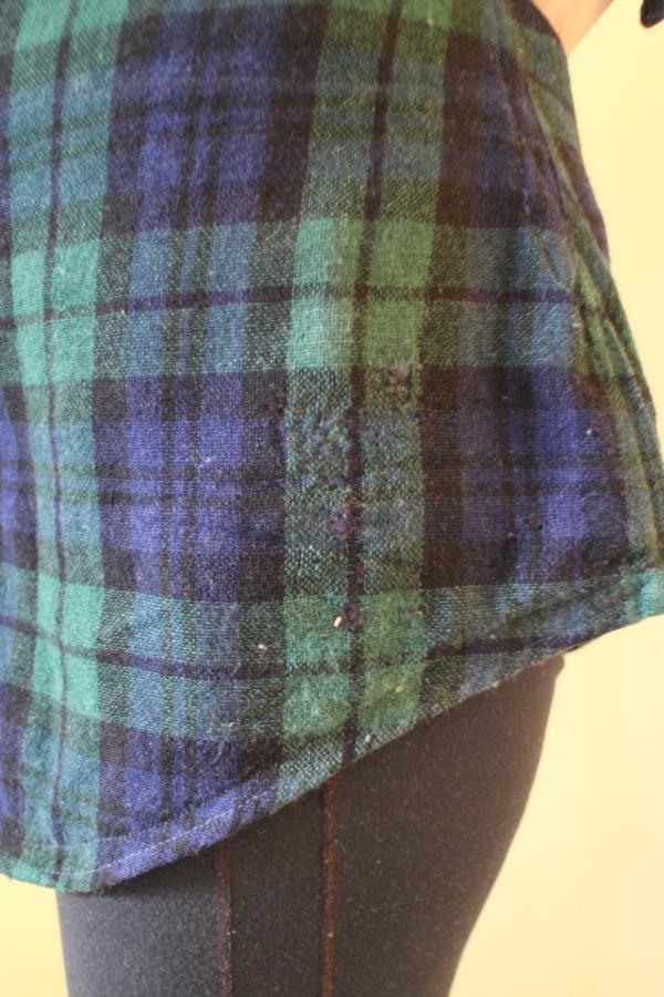 closeup by hip of woman wearing mended black watch shirt