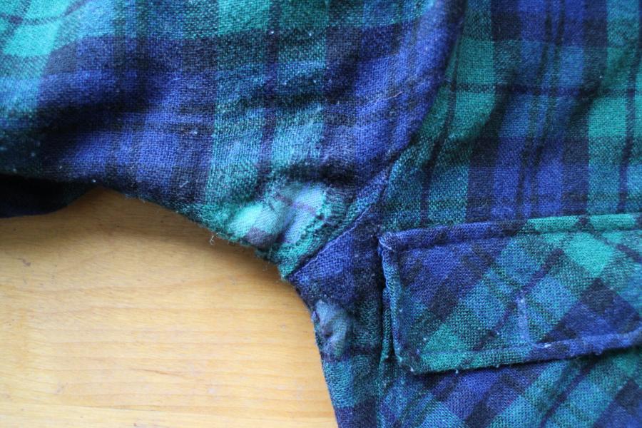 closeup of armpit of black watch shirt mended with interior patch