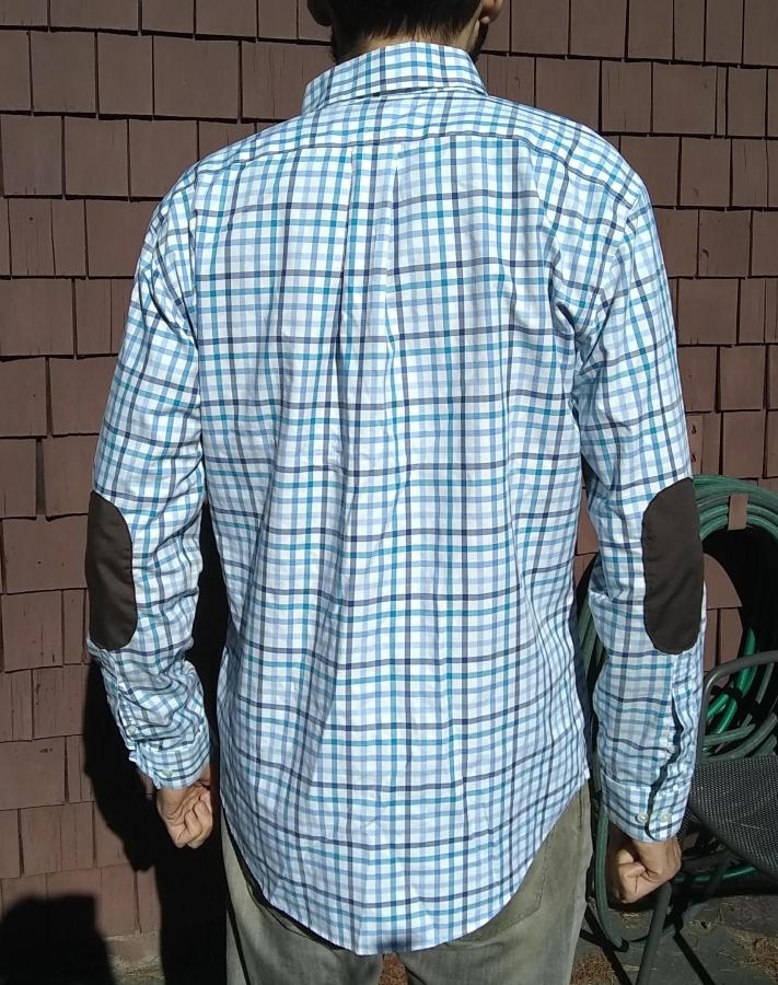 back view of blue plaid shirt with elbow patches, worn by man