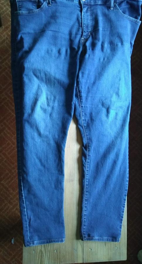 jeans on wooden background, legs are shorted than before but with original hem