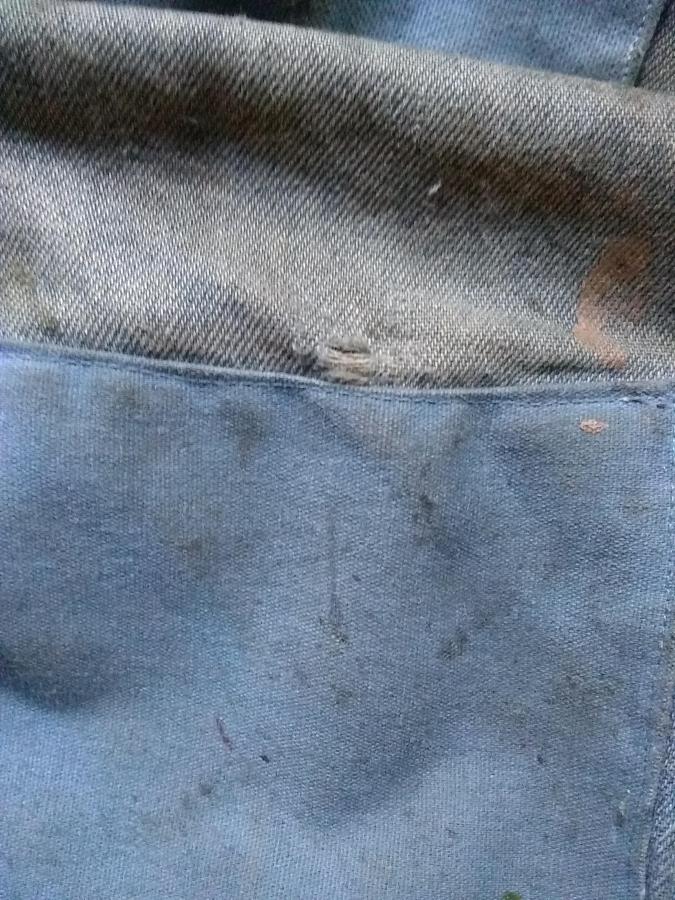 closeup of patched blue jeans with a very small new hole