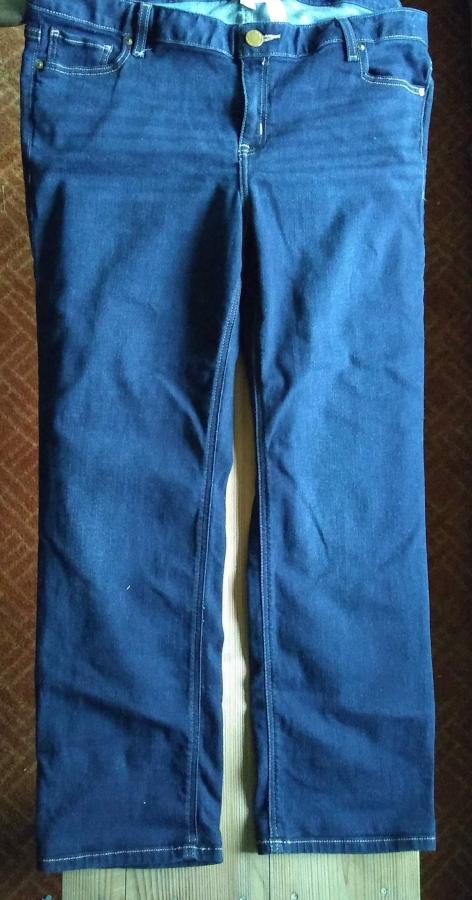 jeans on wooden background, legs are shorted than before but with original hem