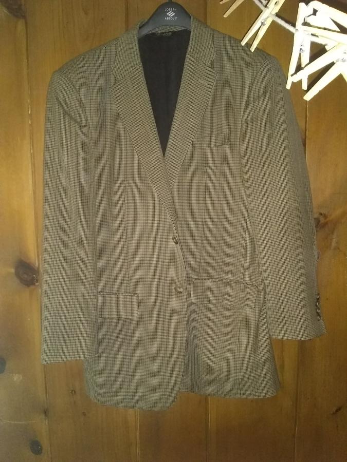sport coat hanging against wooden background