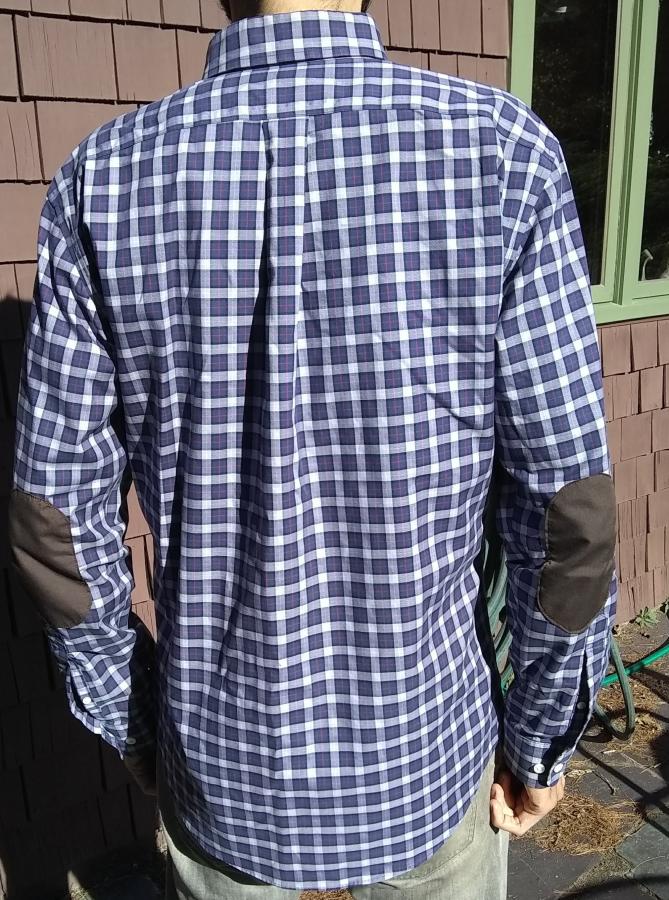 back view of purple plaid shirt with elbow patches, modeled by man