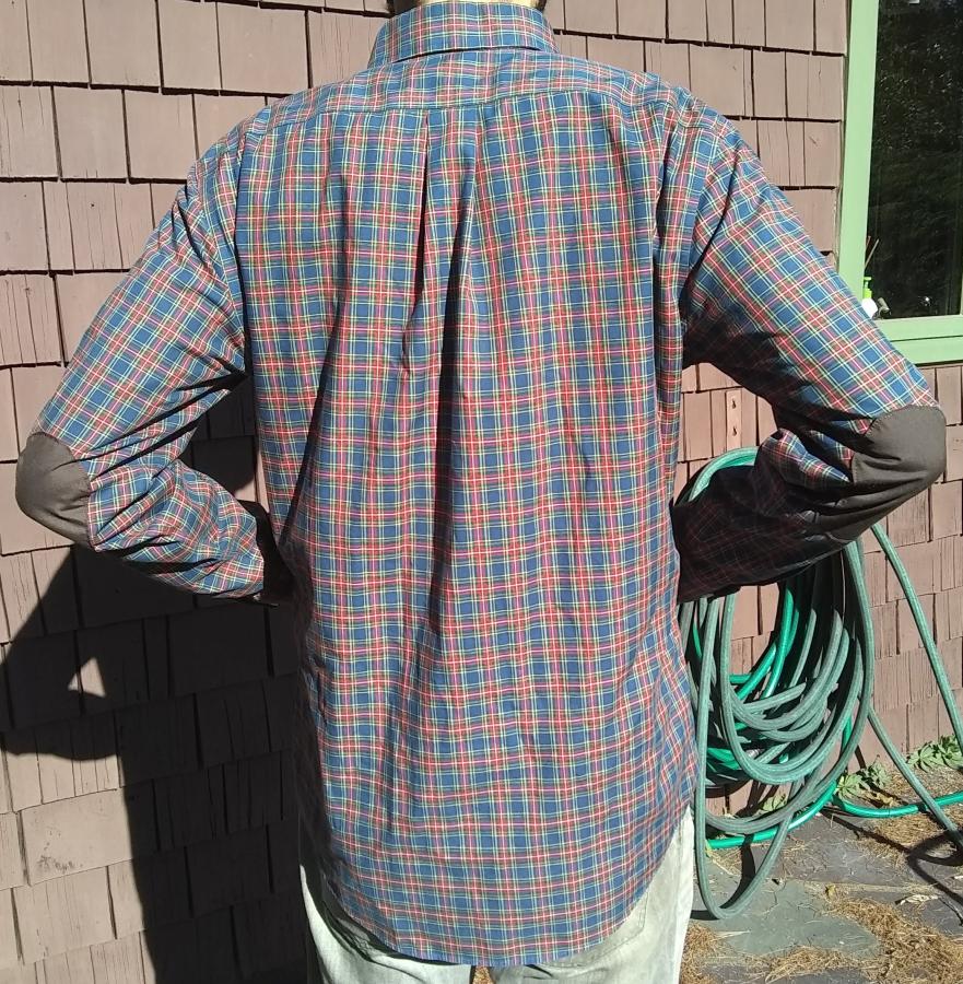 back view with elbow bent of red plaid shirt with elbow patches, worn by man