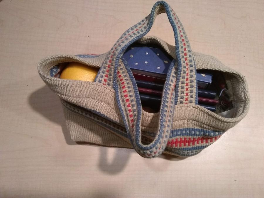 unstained and no holes woven bag holding orange, box of cards, and small planners