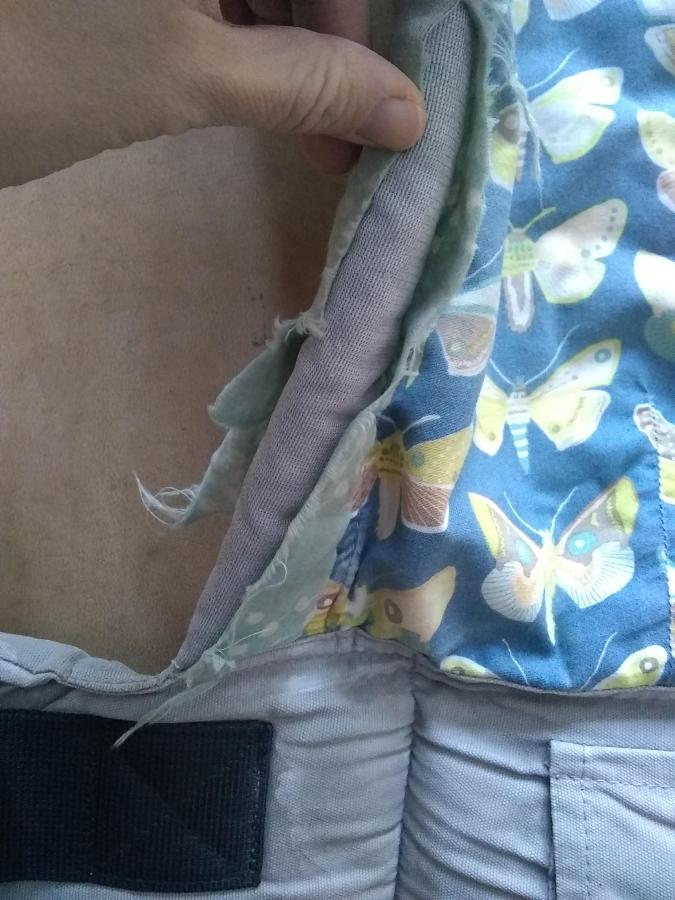 closeup of ripped fabric on baby carrier, side view