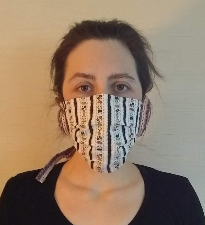 front view of woman wearing pleated face mask with cloth ties
