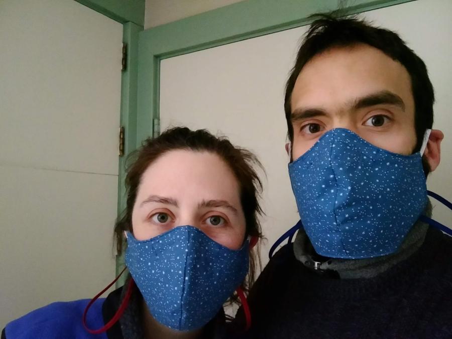 Man and woman wearing matching fitted masks in blue star print