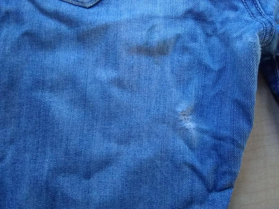 closeup of blue jeans with hole in inner thigh