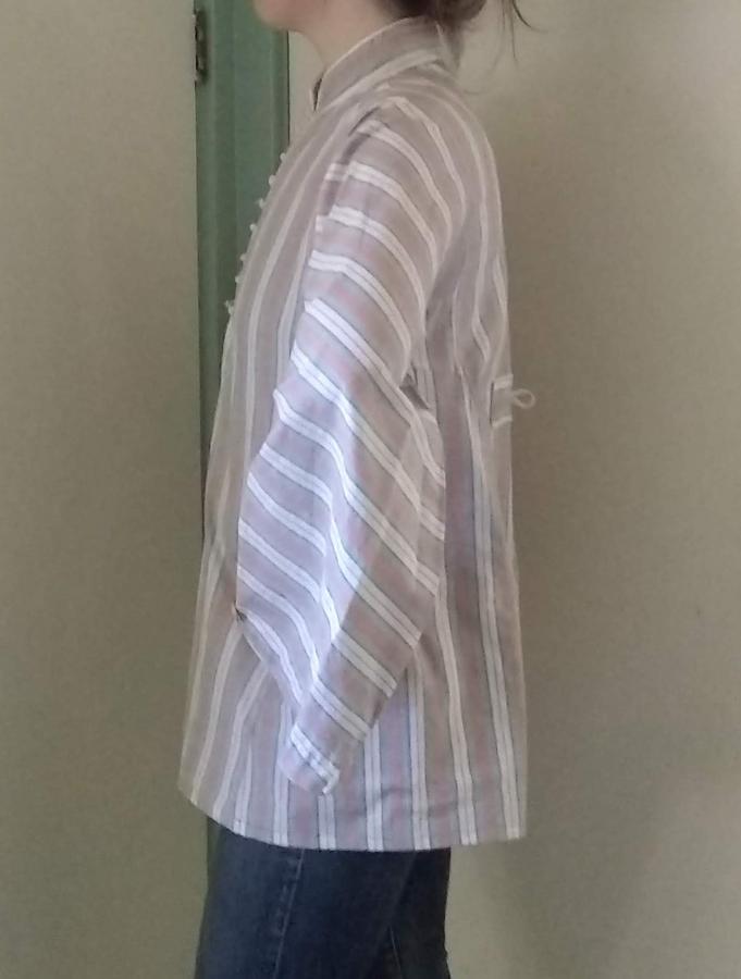 side view of woman wearing unbuttoned tent like shirt with wide sleeves