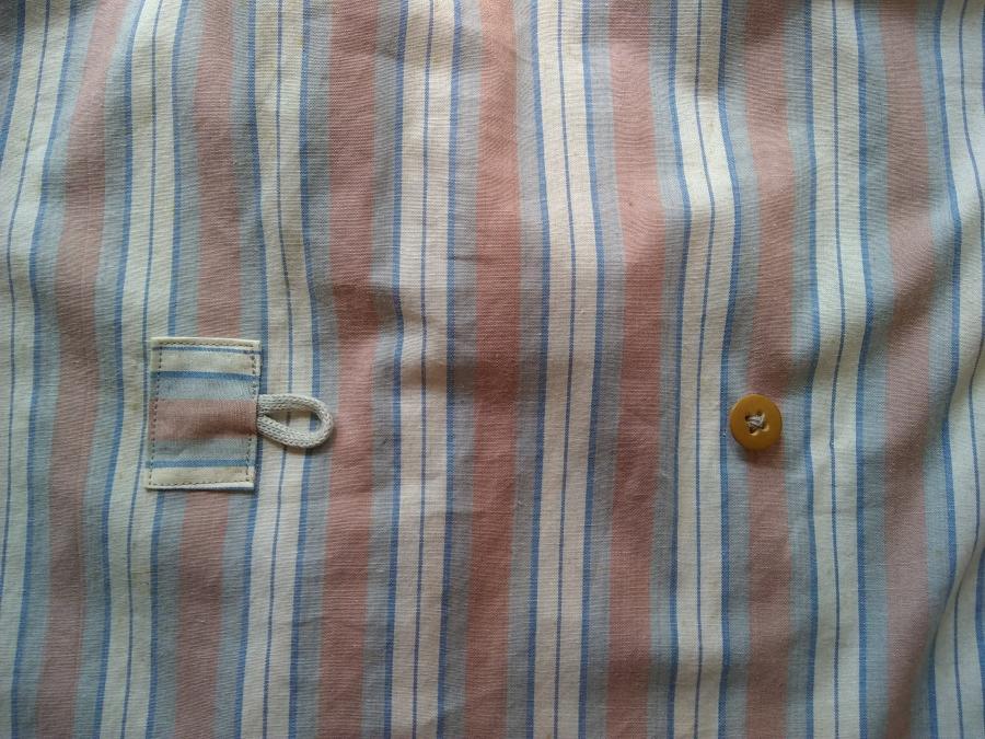 closeup of button and button loop on back of shirt, unbuttoned