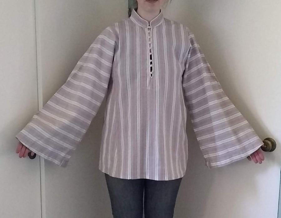 front view of woman wearing striped shirt with wide sleeves and tent shape