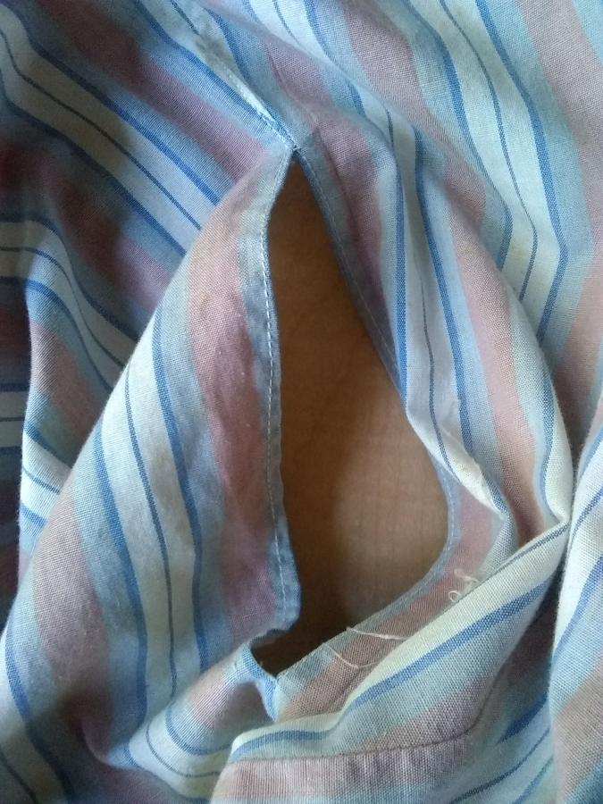 closeup of pocket of kaftan, showing no lining (wood background shows through)