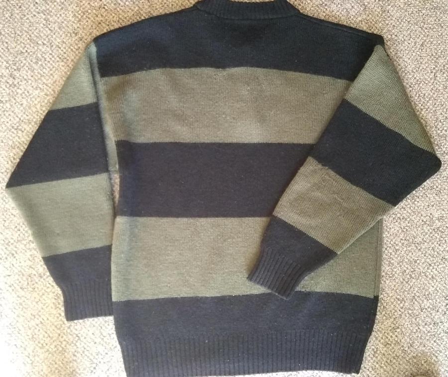 back view of bulky wide striped olive and black sweater with almost invisible mending