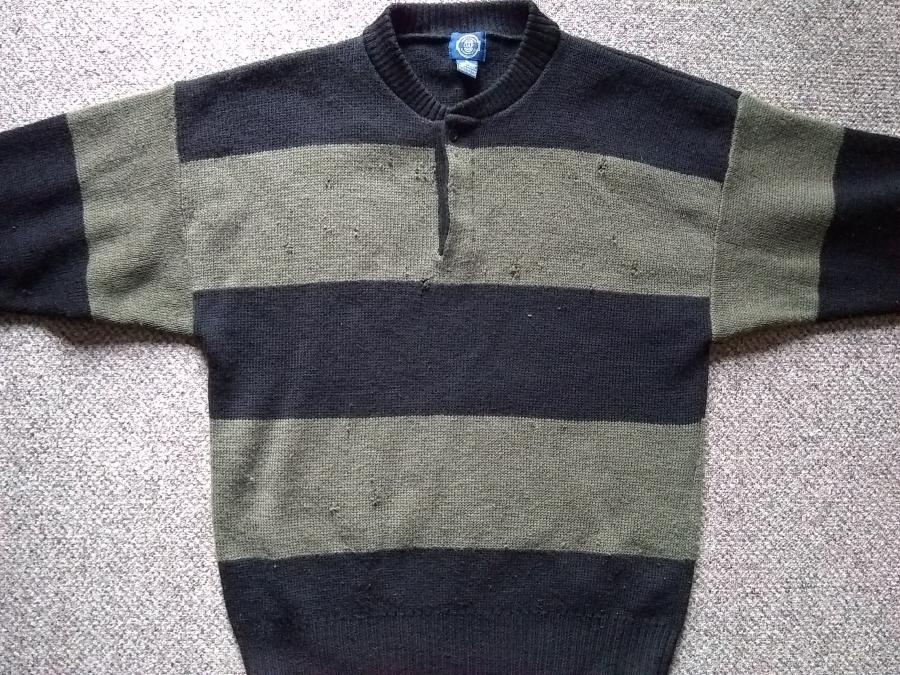 front view of bulky striped sweater with olive and black stripes and visible small holes
