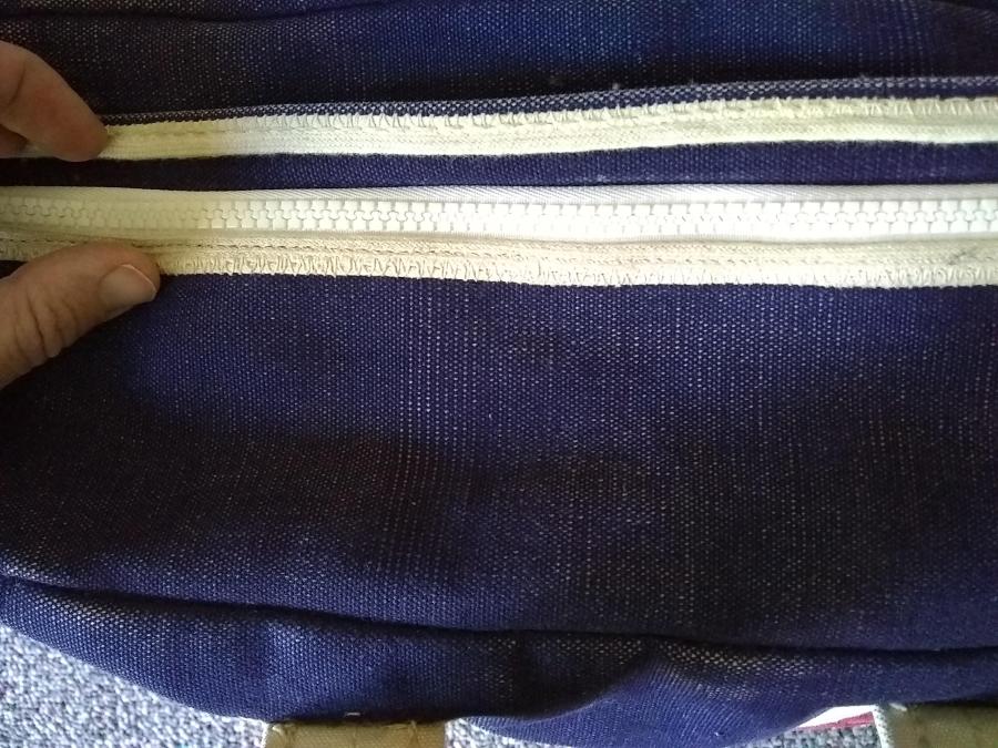 closeup of new zipper on tote bag, zipper closed and with flap pulled back to show it