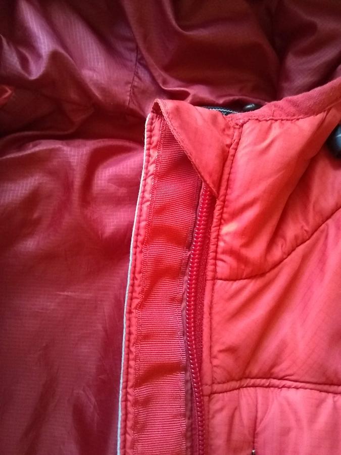 closeup of replaced zipper in jacket, unzipped, showing top tab