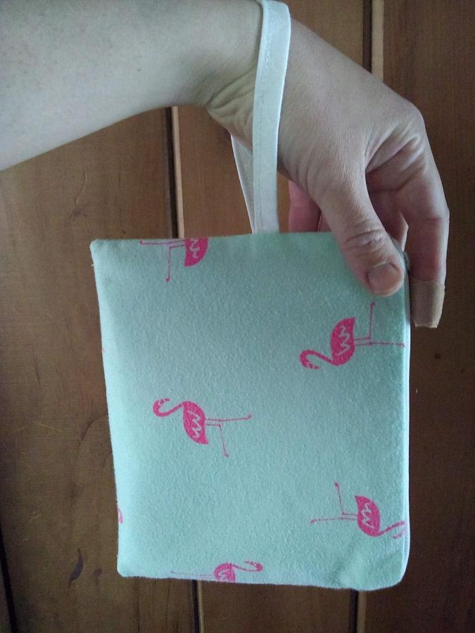 wristlet with wrist strap looped around wrist, hanging down