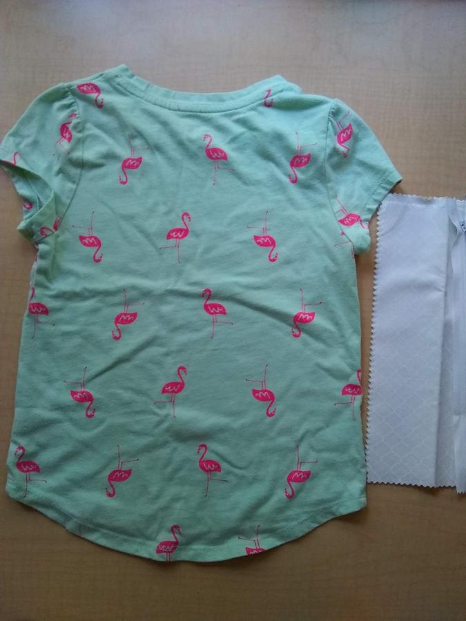 child's t-shirt, used, in pale green with pink flamingos, with some white fabric scraps and a white zipper