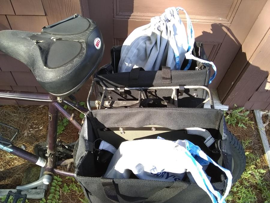 back part of bike, with drawstring bags, closed and half-fall, inside black panniers