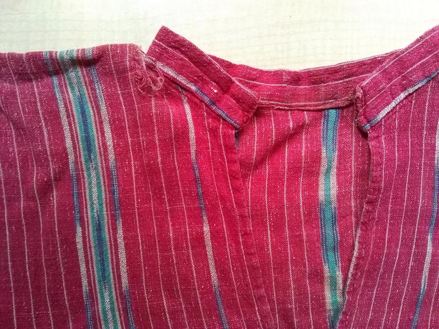 red woven dress with rip at neck, shown from front, detail