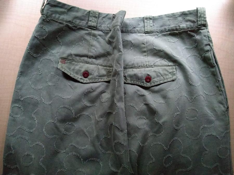 seat of green jeans with safety pin cinching in at center back