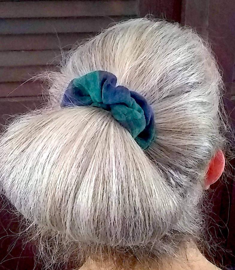 back of woman's hair (gray) wearing black watch plaid scrunchie