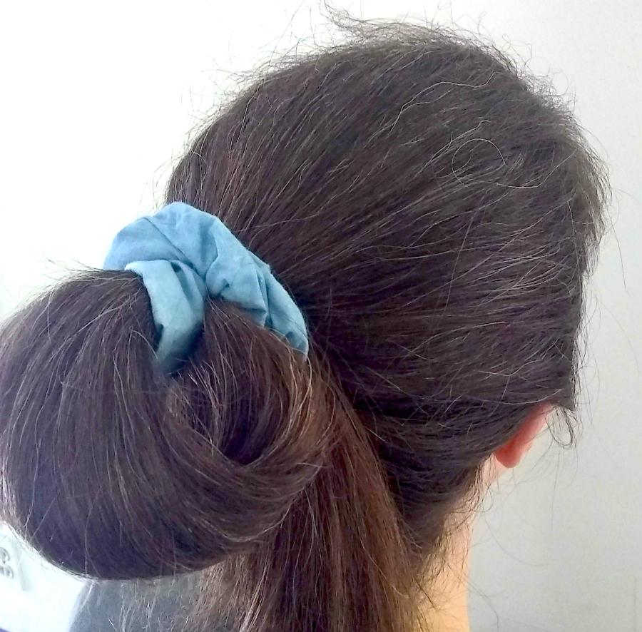 back of woman's hair (brown) wearing bun with puffy blue scrunchie
