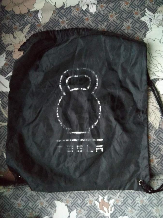 Black cinch bag with faded Tesla logo