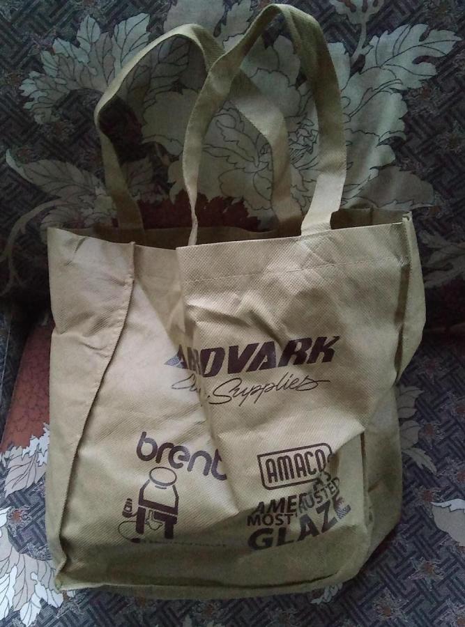 beige tote bag with lots of logos on it
