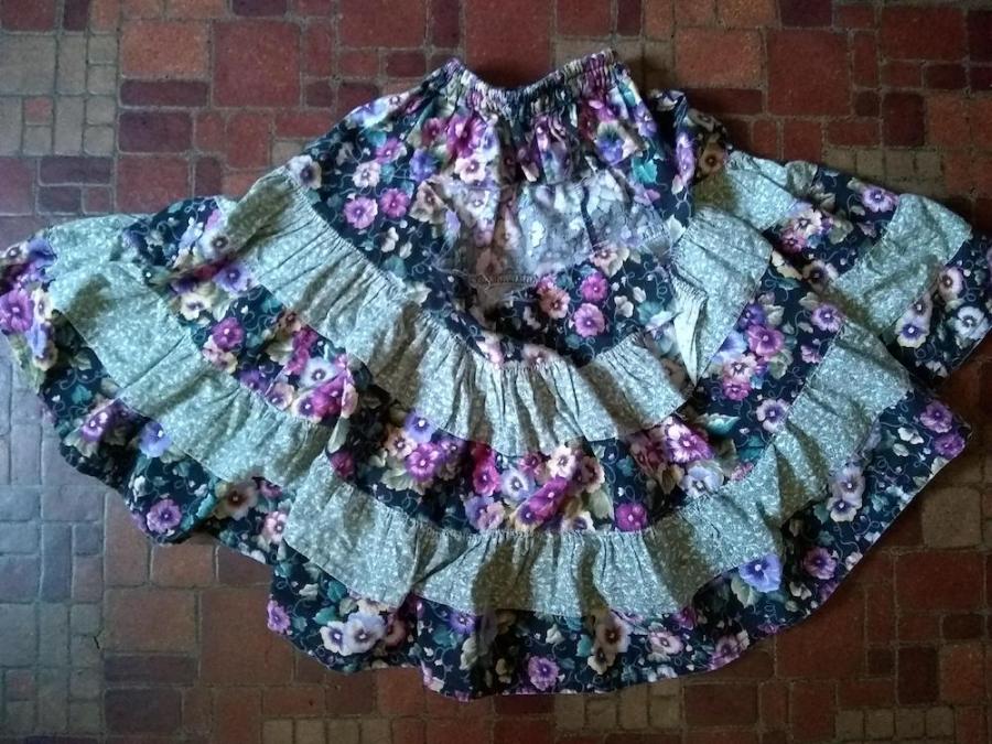 peasant style skirt in two contrasting floral fabrics with large rips in the seams