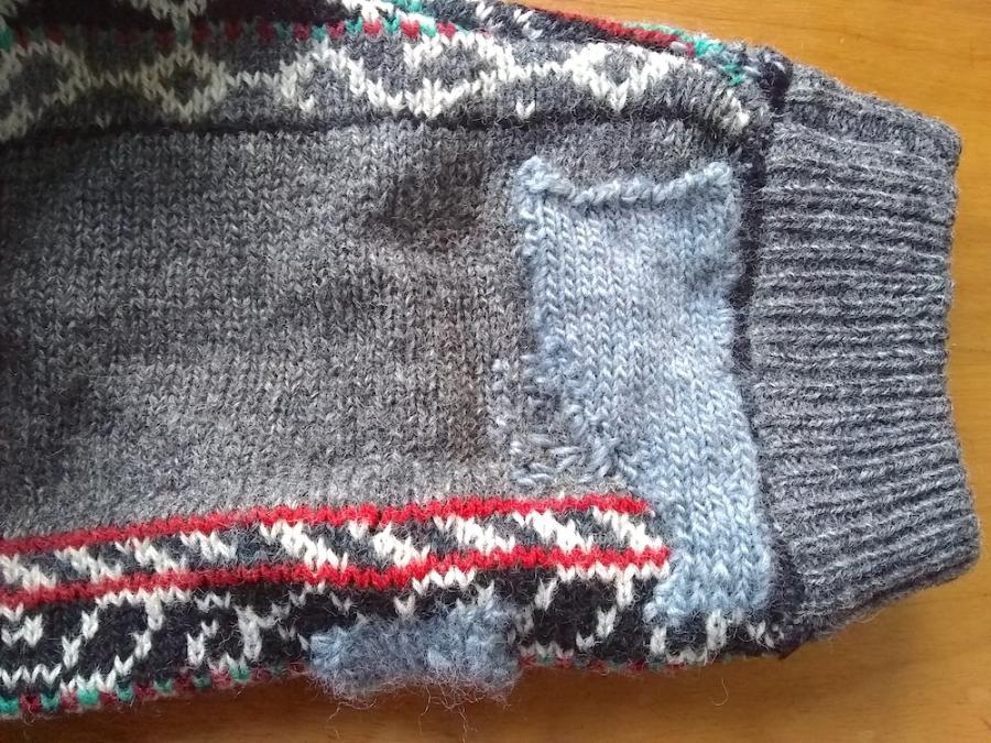Gray and multi patterned sweater sleeve with medium gray knit patch and some gray darns